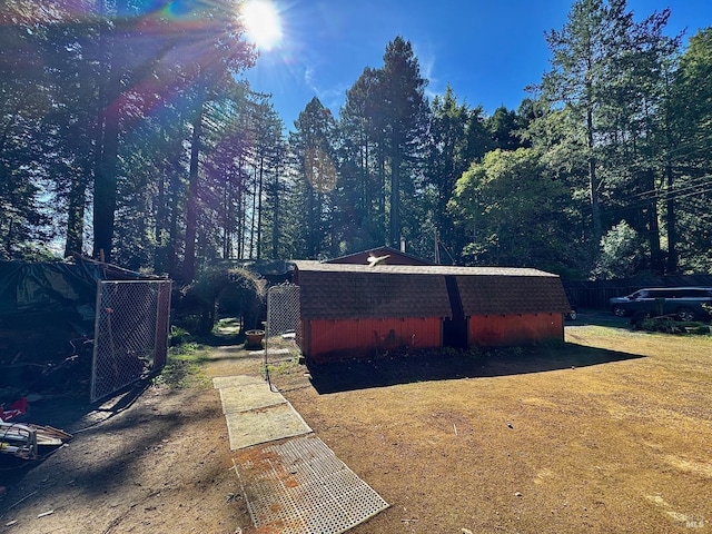 view of yard with an outbuilding, a storage shed, and fence