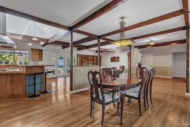 dining room featuring wood finished floors, beamed ceiling, french doors, and wainscoting