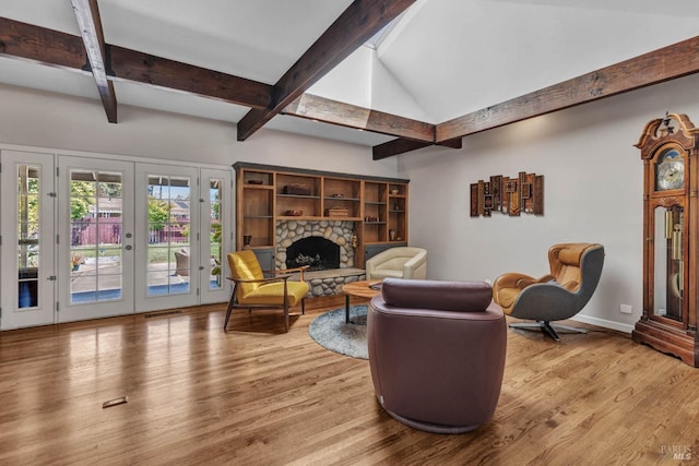 living room featuring french doors, a fireplace, lofted ceiling with beams, wood finished floors, and baseboards