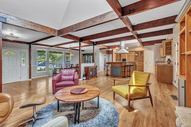 living area with light wood-type flooring, visible vents, coffered ceiling, and beam ceiling