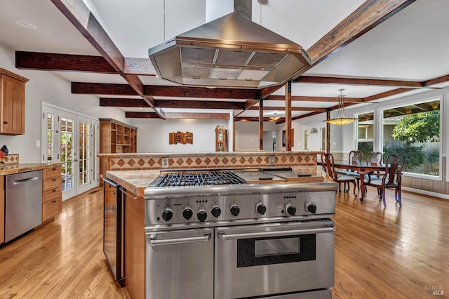 kitchen featuring light wood finished floors, stainless steel appliances, and a wealth of natural light