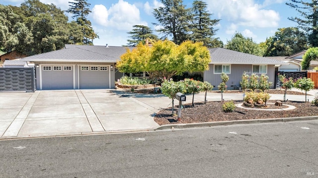 ranch-style house with a garage, driveway, a shingled roof, and fence