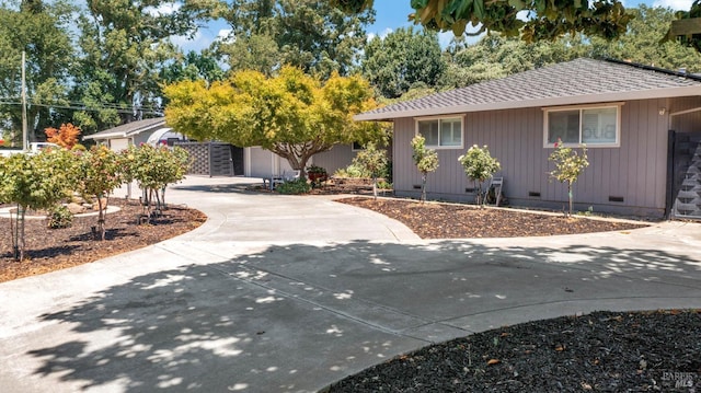 view of front of property with a shingled roof, crawl space, and concrete driveway