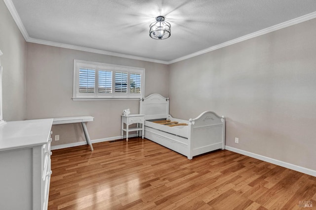 unfurnished bedroom featuring light wood-style floors, ornamental molding, and baseboards