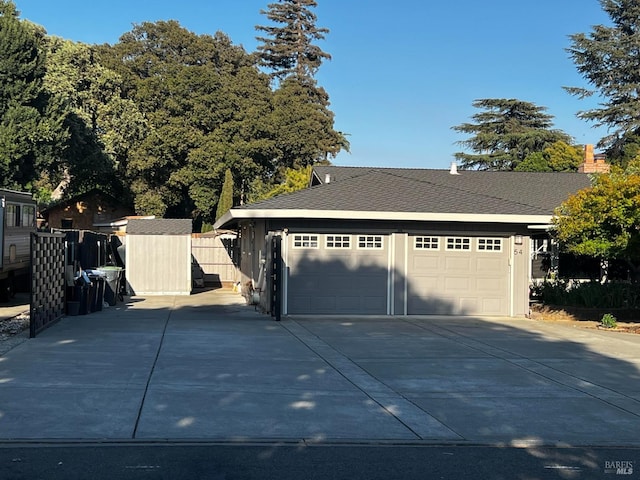 detached garage with a storage unit and fence