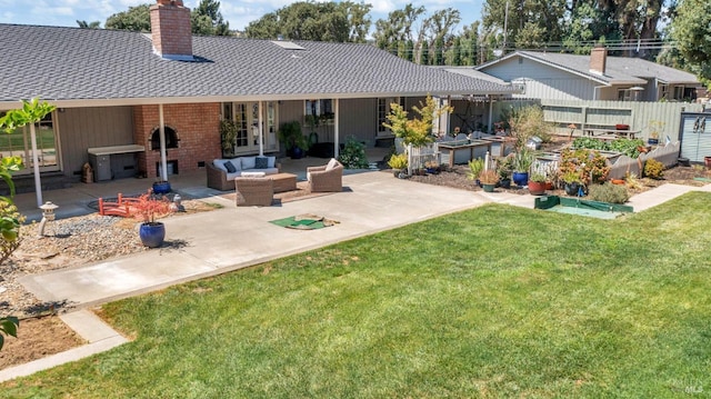 rear view of house with a vegetable garden, a patio, fence, a yard, and outdoor lounge area