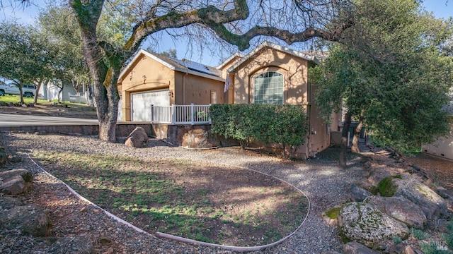 view of side of property with solar panels and stucco siding