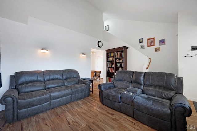 living room featuring wood-type flooring and high vaulted ceiling