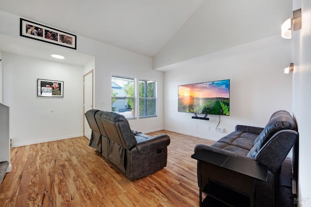 living room with high vaulted ceiling and light hardwood / wood-style flooring