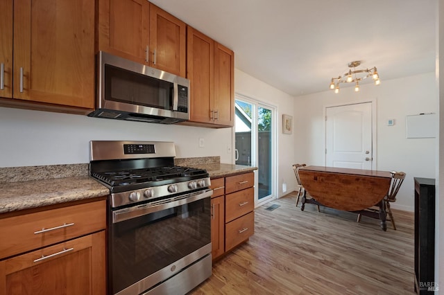 kitchen featuring stainless steel appliances and light hardwood / wood-style floors