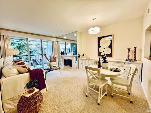 carpeted dining area featuring a wall of windows