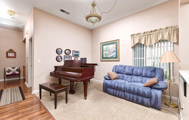 sitting room with baseboards, visible vents, and wood finished floors