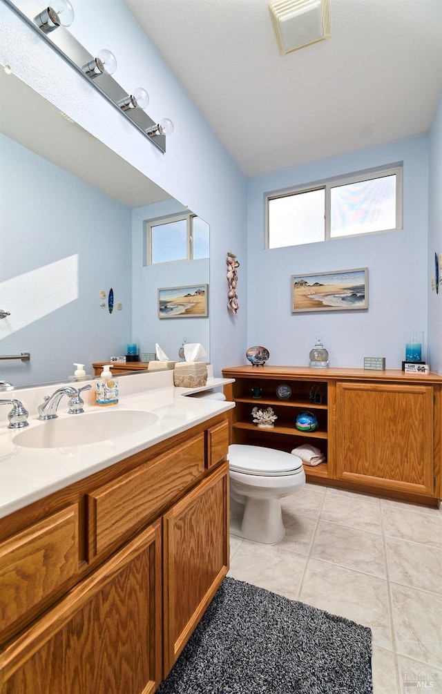 bathroom featuring tile patterned flooring, vanity, and toilet