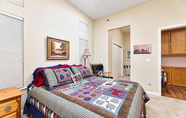 carpeted bedroom featuring a closet and baseboards