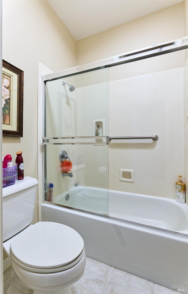 full bathroom with combined bath / shower with glass door, toilet, and tile patterned floors