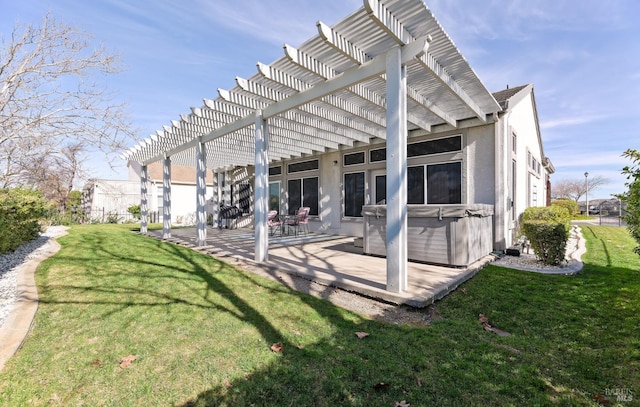 back of house featuring a yard, stucco siding, a pergola, a patio area, and a hot tub