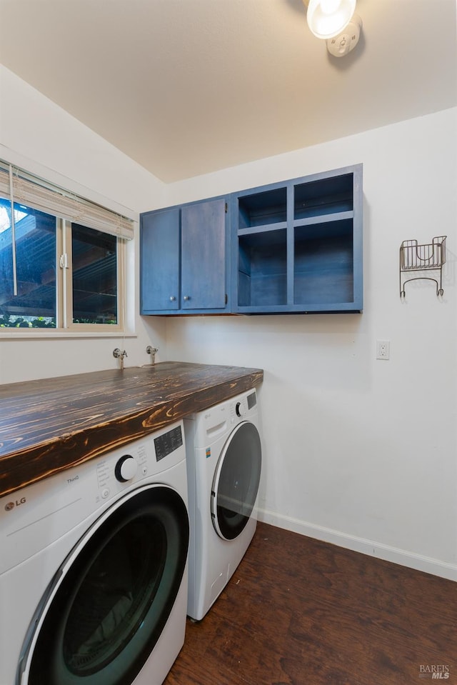 laundry room featuring cabinets, washing machine and dryer, and dark hardwood / wood-style flooring