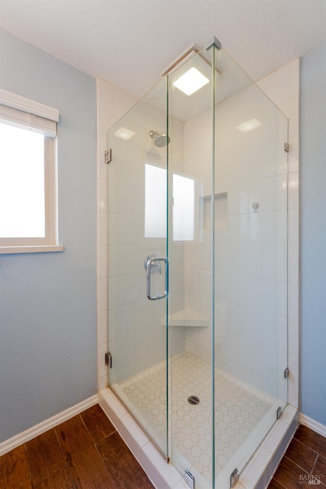 bathroom with wood-type flooring and a shower with shower door