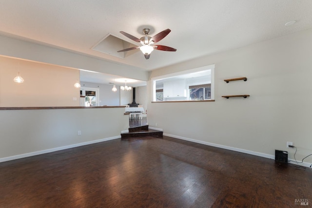 unfurnished living room with dark wood-type flooring and ceiling fan