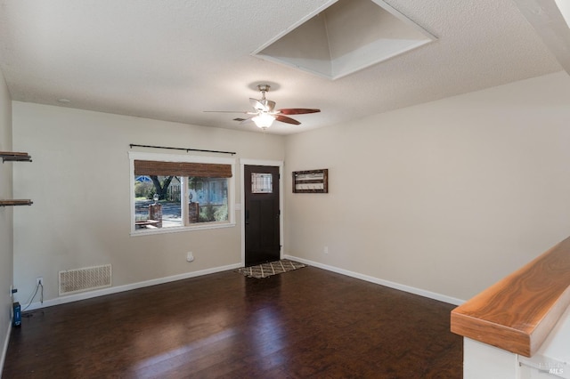 foyer with ceiling fan, dark hardwood / wood-style floors, and a textured ceiling