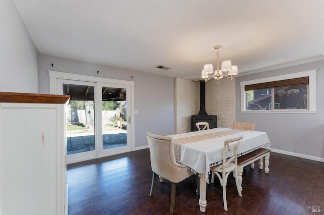 dining area featuring dark wood-type flooring, a textured ceiling, and a wood stove