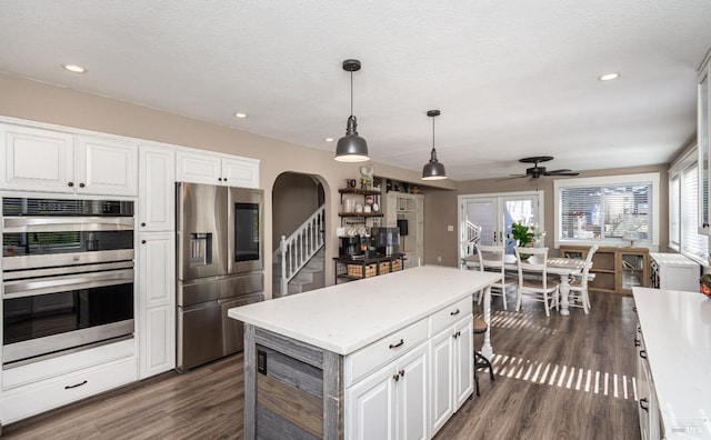 1061 Steele Canyon Rd, Napa, CA 94558 - kitchen with a healthy amount of sunlight, white cabinetry, arched walkways, and stainless steel appliances