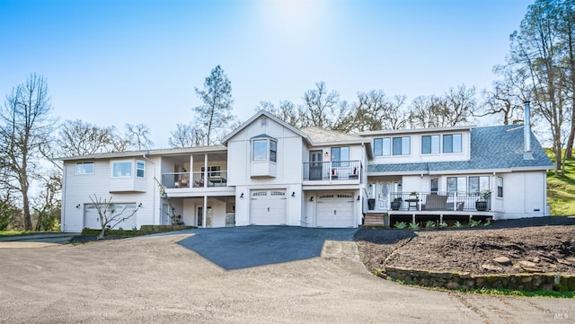 view of front facade featuring driveway, an attached garage, and roof with shingles