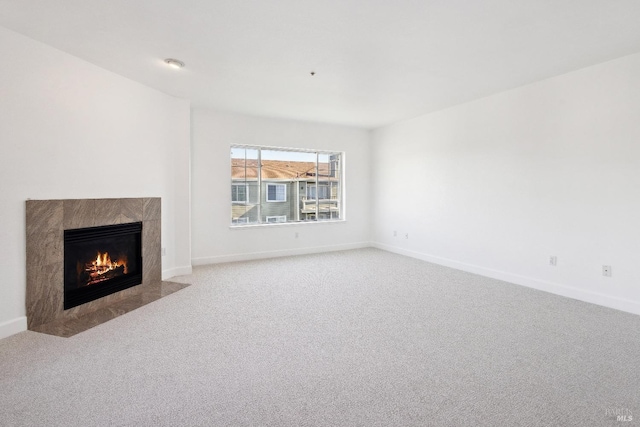 unfurnished living room featuring a tile fireplace and light carpet