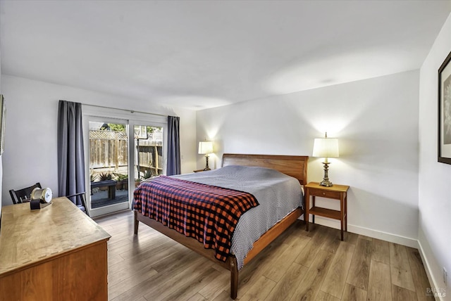 bedroom with wood-type flooring and access to outside