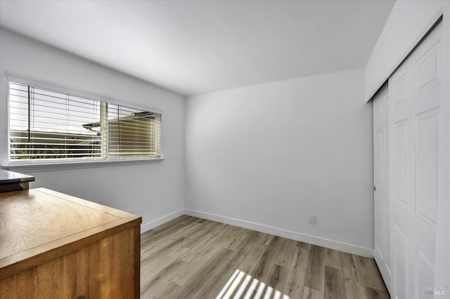 unfurnished bedroom featuring light hardwood / wood-style flooring and a closet