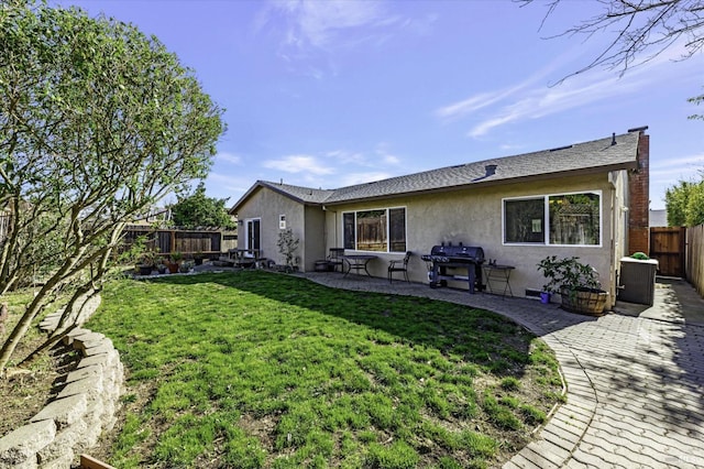 rear view of house with a yard and a patio