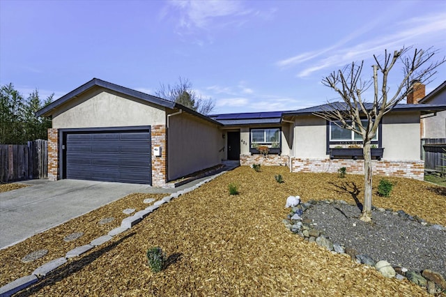 ranch-style house with a garage and solar panels