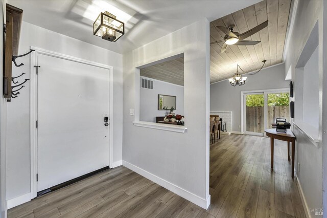 foyer with hardwood / wood-style flooring, lofted ceiling, wood ceiling, and ceiling fan with notable chandelier