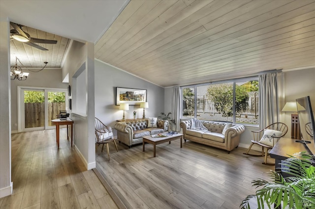 living room with vaulted ceiling, ornamental molding, light hardwood / wood-style floors, and a chandelier