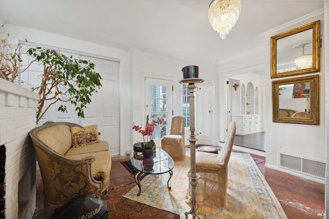 sitting room with ornamental molding, dark tile patterned flooring, and a notable chandelier