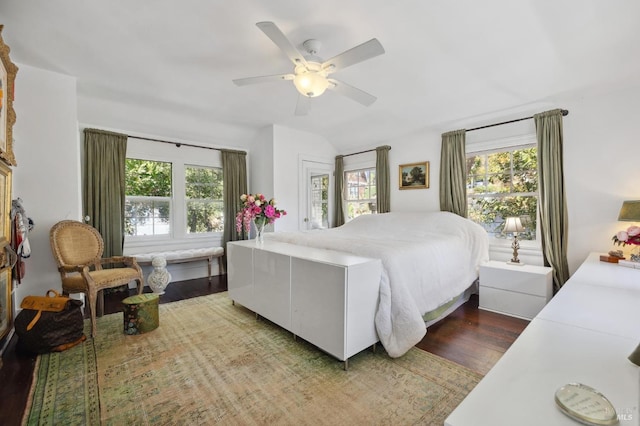 bedroom featuring multiple windows, lofted ceiling, dark wood-type flooring, and ceiling fan