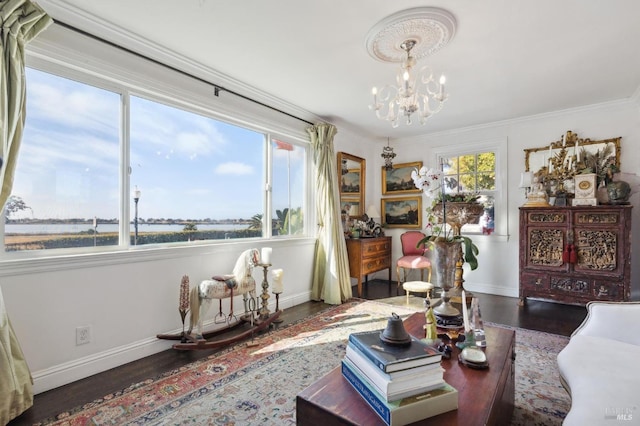 living room with dark hardwood / wood-style flooring, an inviting chandelier, a healthy amount of sunlight, and a water view