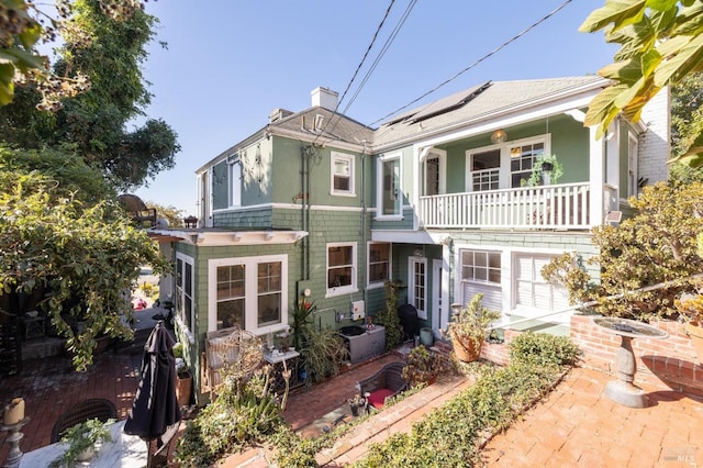 view of front of house featuring a balcony and solar panels