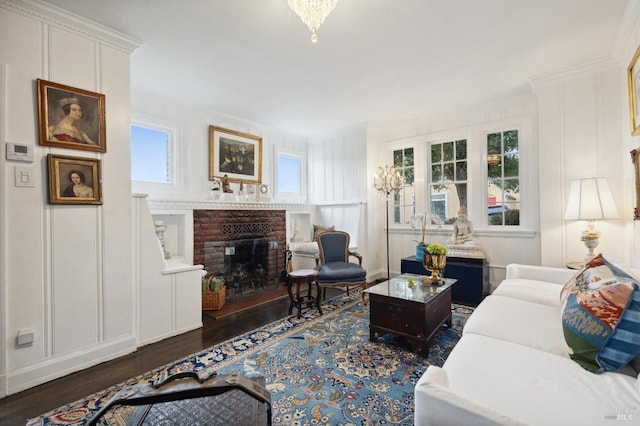 living room featuring a brick fireplace, dark wood-type flooring, and ornamental molding