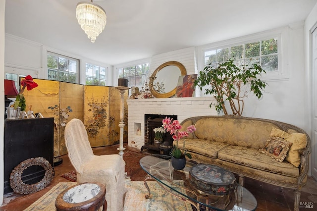 living room featuring a brick fireplace, a notable chandelier, and a wealth of natural light