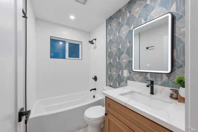 full bathroom featuring tiled shower / bath, vanity, and toilet