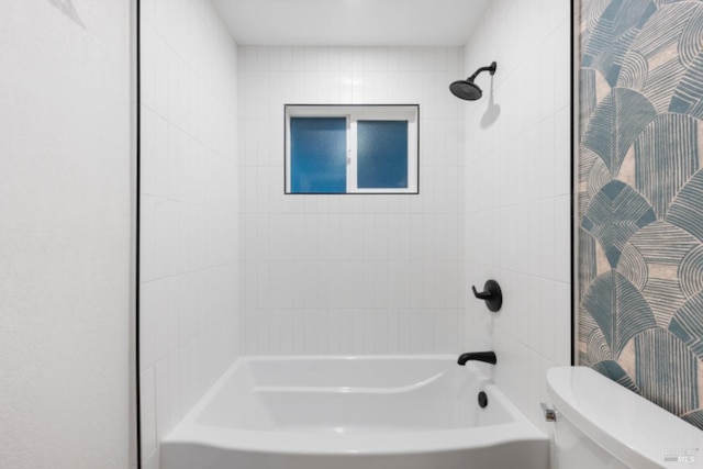 bathroom featuring tiled shower / bath and toilet