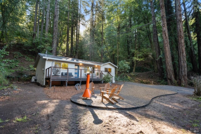 view of front facade with a deck and a fire pit