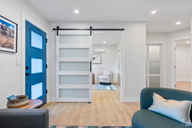 interior space with a barn door and light hardwood / wood-style floors