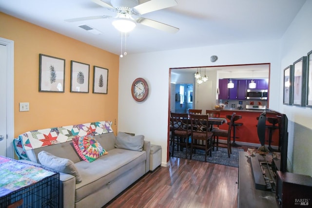 living room featuring ceiling fan and dark hardwood / wood-style flooring