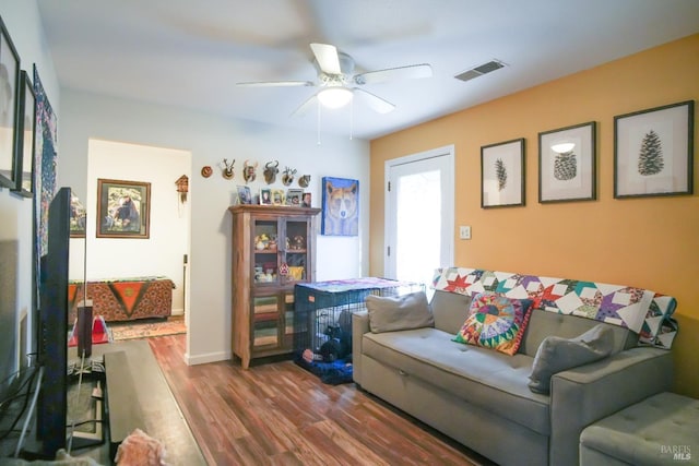 living room featuring wood-type flooring and ceiling fan