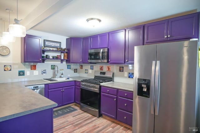 kitchen featuring blue cabinetry, stainless steel appliances, sink, and hanging light fixtures