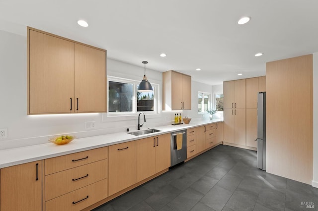 kitchen featuring light brown cabinetry, a sink, light countertops, and stainless steel appliances