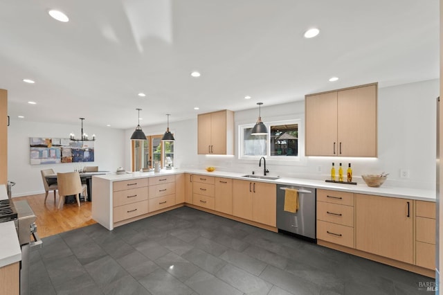 kitchen with a peninsula, light countertops, light brown cabinetry, stainless steel dishwasher, and a sink