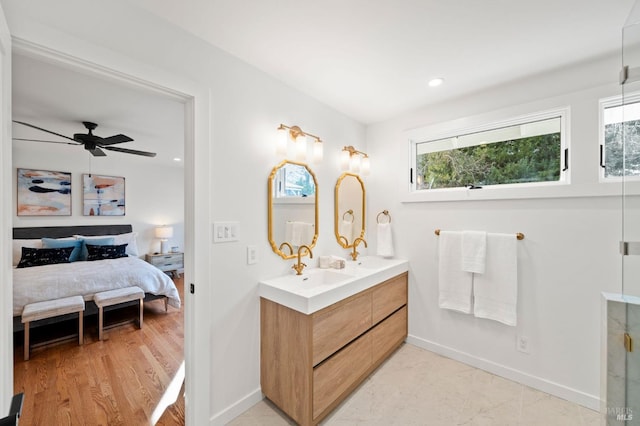 ensuite bathroom with double vanity, a sink, baseboards, and ensuite bathroom